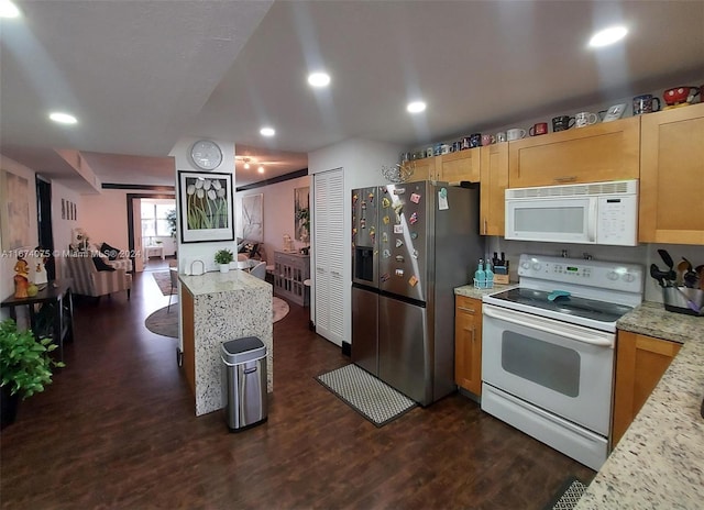 kitchen with light brown cabinetry, light stone counters, white appliances, and dark hardwood / wood-style floors