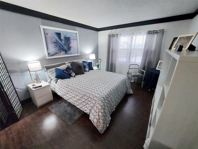 bedroom featuring a textured ceiling, dark hardwood / wood-style floors, and crown molding