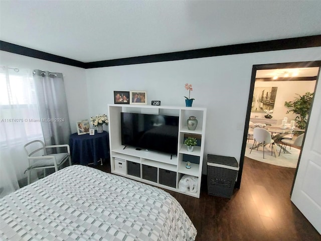 bedroom with ornamental molding and dark wood-type flooring