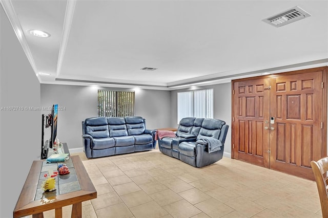 living room with light tile patterned flooring and crown molding