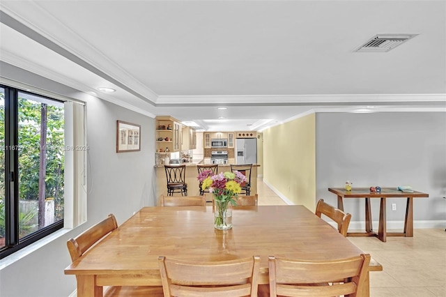 dining space with ornamental molding and light tile patterned floors