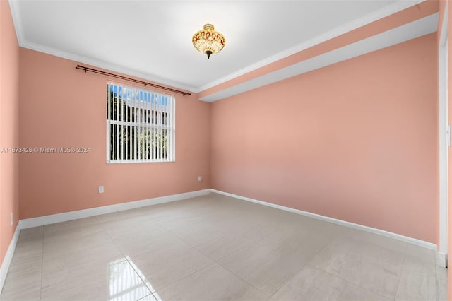 tiled empty room featuring crown molding