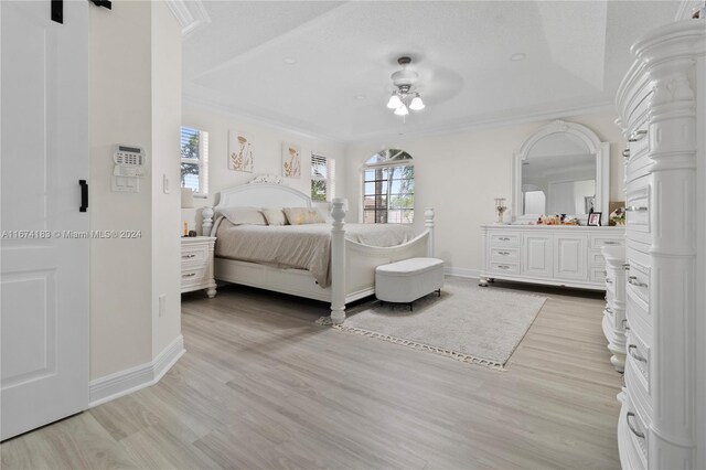 bedroom featuring ornamental molding, baseboards, a ceiling fan, and light wood-style floors