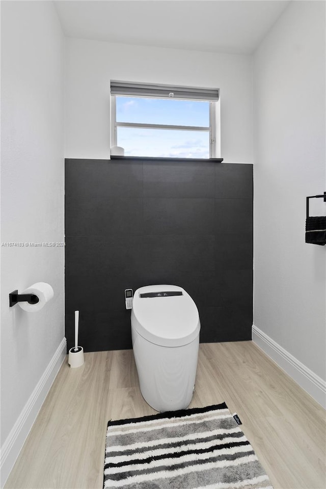 bathroom featuring baseboards, toilet, and wood finished floors