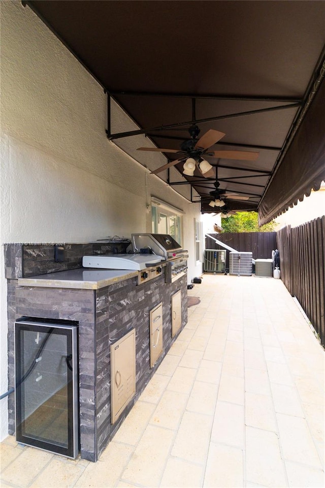view of patio / terrace featuring area for grilling, a grill, a ceiling fan, and fence