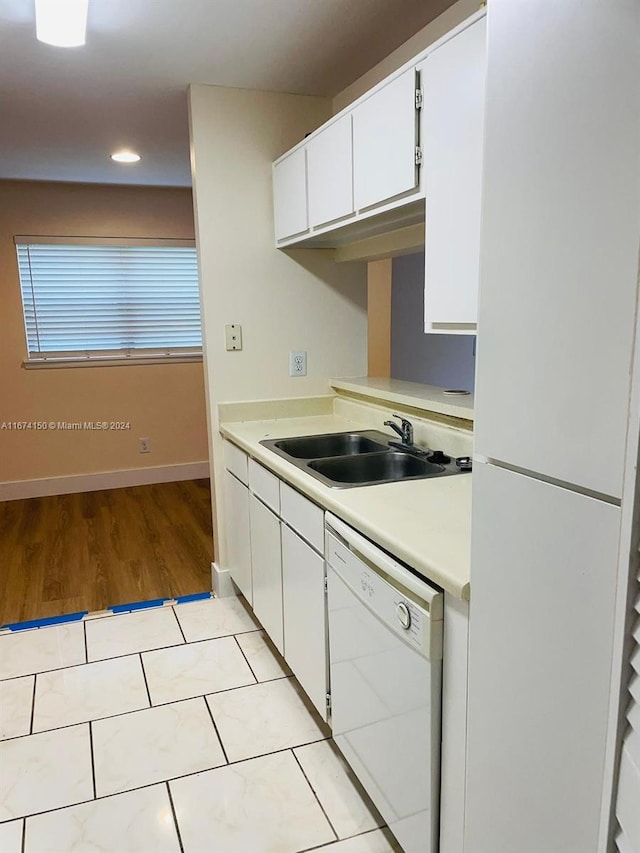 kitchen with sink, white cabinetry, light hardwood / wood-style flooring, and white appliances