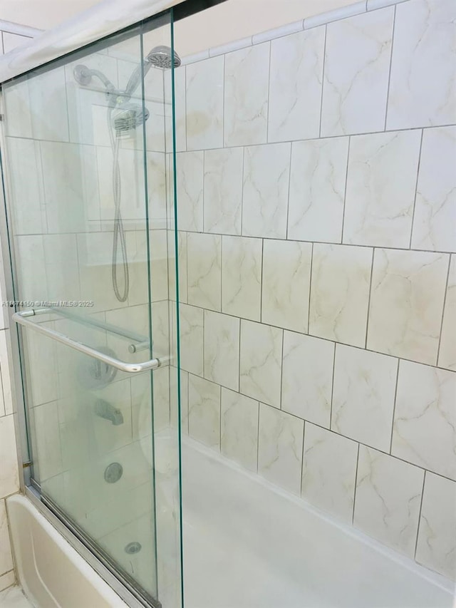 bathroom with combined bath / shower with glass door