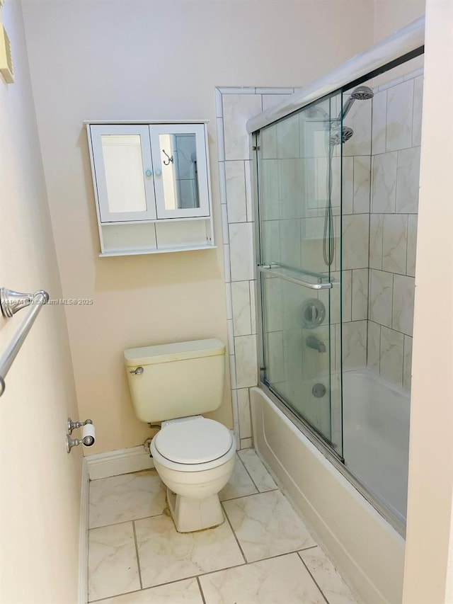 bathroom featuring bath / shower combo with glass door and toilet