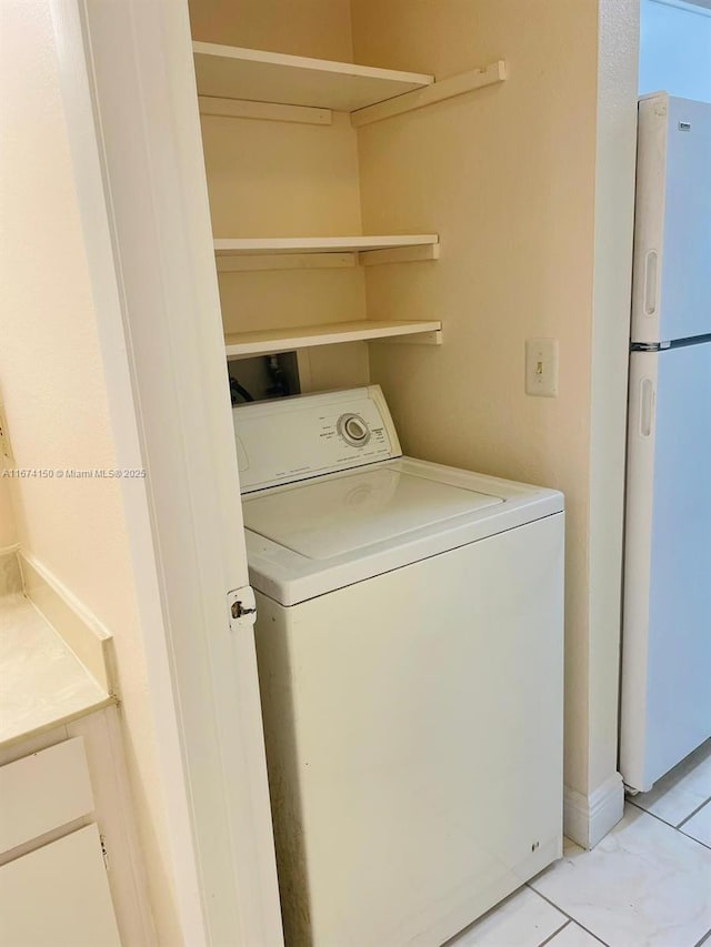 laundry room with washer / clothes dryer and light tile patterned floors