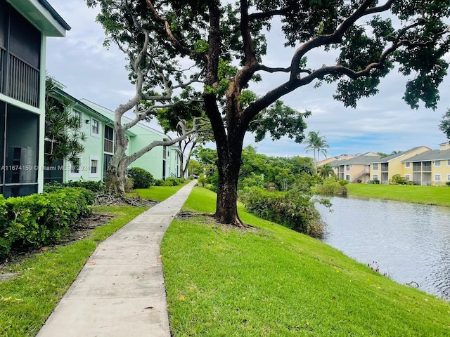 surrounding community with a yard and a water view