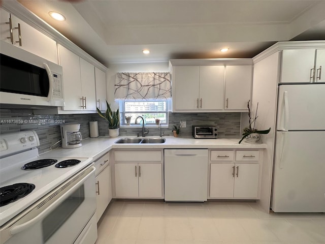 kitchen with white cabinets, sink, white appliances, and decorative backsplash