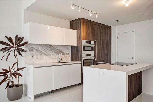 kitchen featuring tasteful backsplash, stainless steel double oven, black electric cooktop, sink, and white cabinets