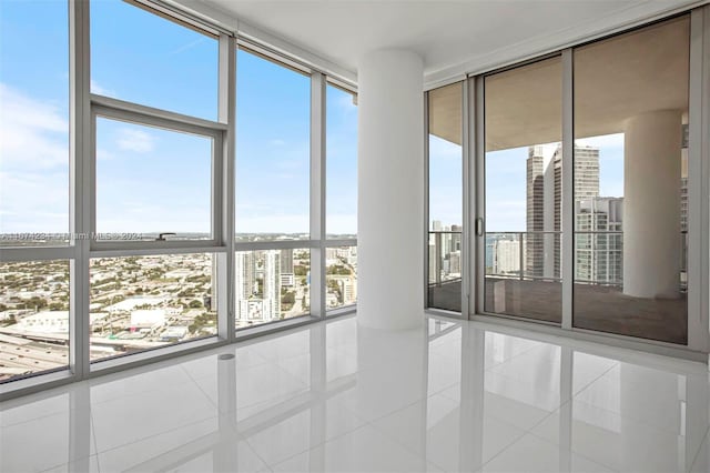 spare room featuring tile patterned flooring, plenty of natural light, and floor to ceiling windows