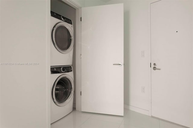 washroom featuring light tile patterned flooring and stacked washer / dryer