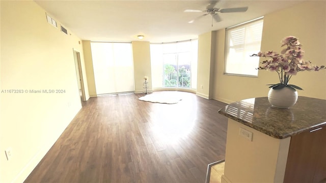 unfurnished living room featuring ceiling fan and dark hardwood / wood-style flooring