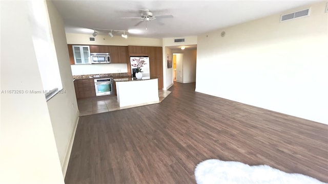 kitchen featuring dark hardwood / wood-style floors, stainless steel appliances, and ceiling fan