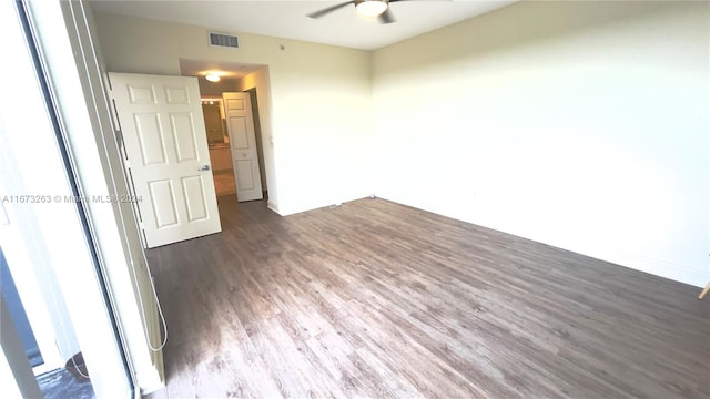 unfurnished room with ceiling fan, a healthy amount of sunlight, and dark hardwood / wood-style flooring