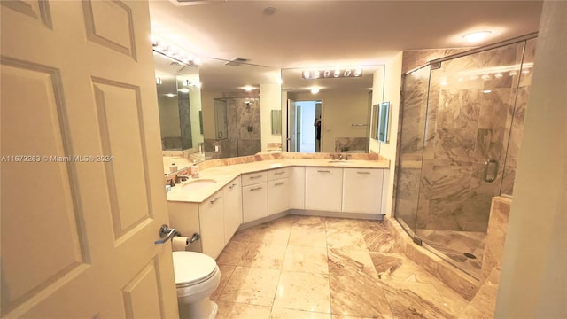 bathroom featuring vanity, toilet, and a shower with shower door