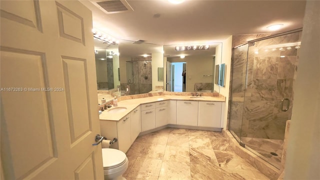 bathroom with vanity, a shower with shower door, and toilet