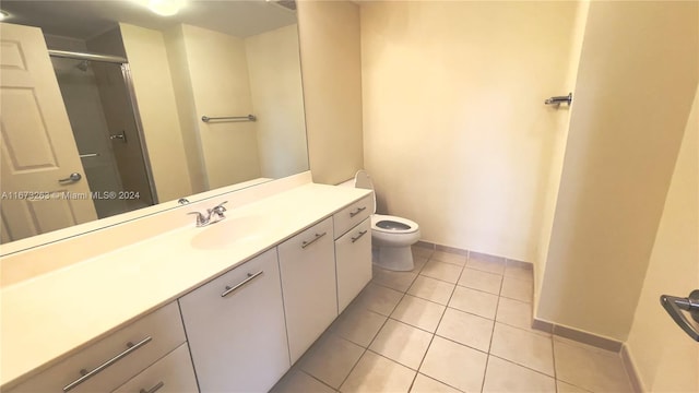 bathroom featuring vanity, toilet, walk in shower, and tile patterned flooring