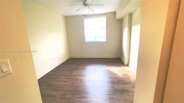 unfurnished room featuring dark wood-type flooring and ceiling fan