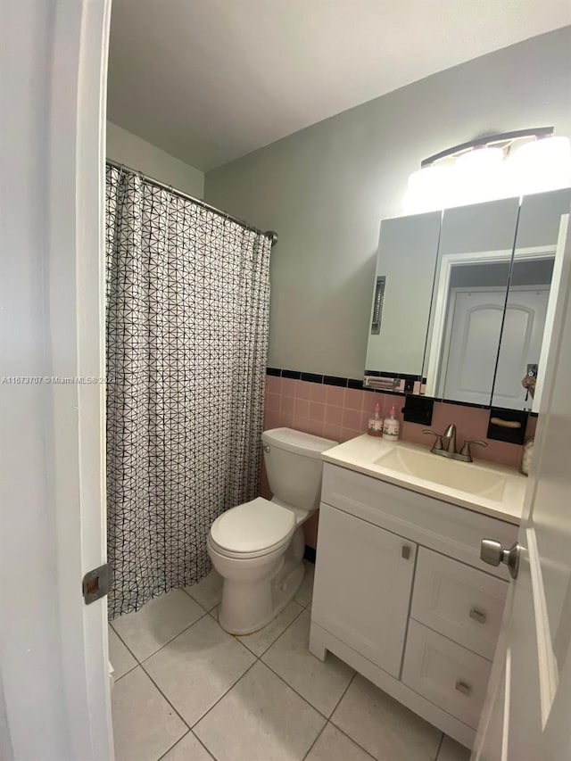 bathroom with tile patterned flooring, toilet, tile walls, a shower with shower curtain, and vanity