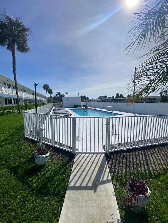 view of swimming pool featuring a yard