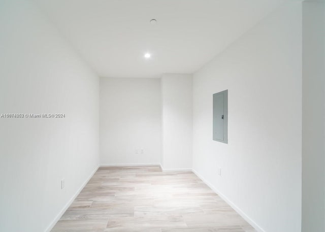 empty room with electric panel and light hardwood / wood-style floors