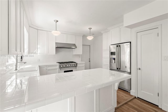 kitchen with white cabinets, pendant lighting, stainless steel appliances, and tile counters