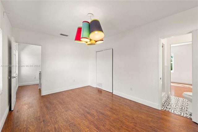 unfurnished bedroom with dark hardwood / wood-style flooring