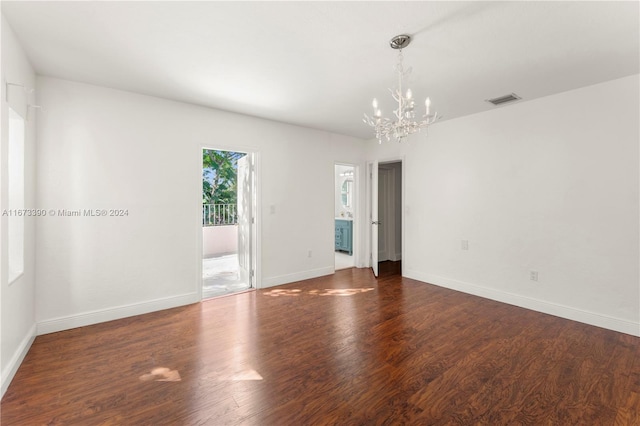 empty room featuring dark hardwood / wood-style flooring and a chandelier