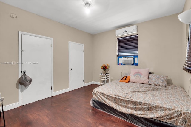 bedroom featuring a wall unit AC, cooling unit, and dark hardwood / wood-style flooring