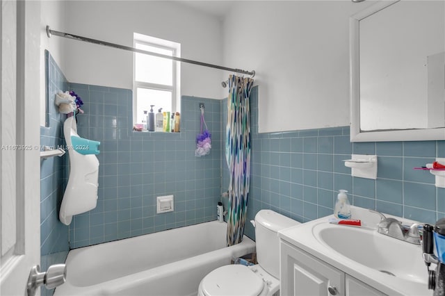 full bathroom with shower / bath combination with curtain, vanity, tile walls, and toilet