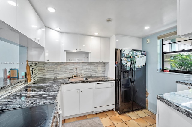 kitchen with white dishwasher, white cabinets, black fridge, sink, and light tile patterned flooring