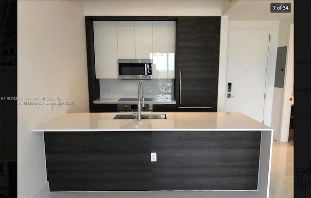 kitchen featuring white cabinetry, sink, and tasteful backsplash