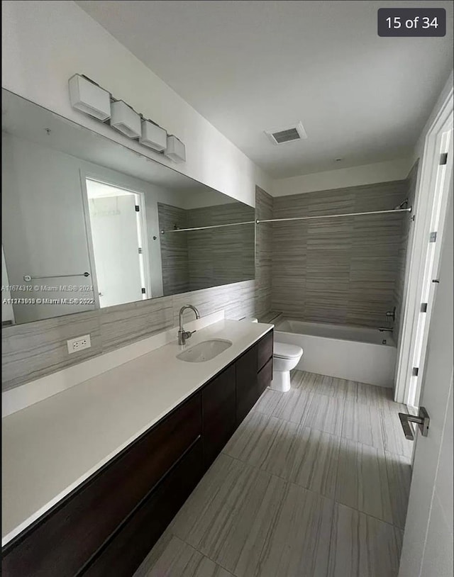 full bathroom with vanity, toilet, and tiled shower / bath combo