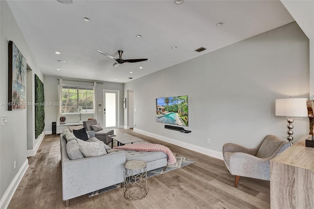 living room with wood-type flooring and ceiling fan