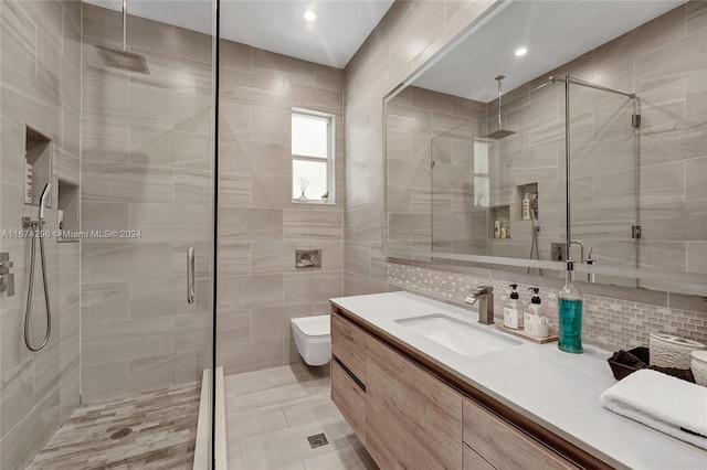 bathroom featuring toilet, tile walls, decorative backsplash, a shower with shower door, and vanity