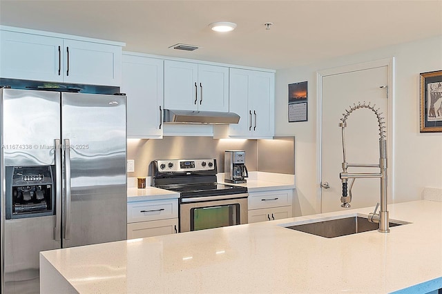 9066 SW 73rd Ct Unit 1205, Miami, FL 33156 - kitchen featuring appliances with stainless steel finishes, under cabinet range hood, a sink, light stone counters, and white cabinetry