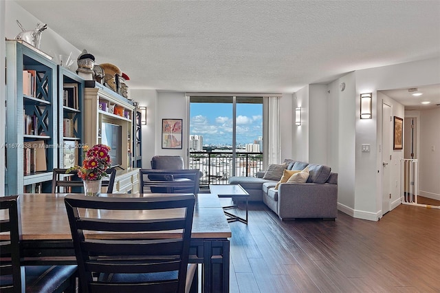 9066 SW 73rd Ct Unit 1205, Miami, FL 33156 - living area with wood finished floors, a textured ceiling, baseboards, and a wall of windows