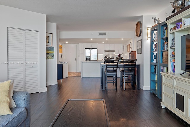 living area featuring dark wood finished floors, visible vents, and baseboards