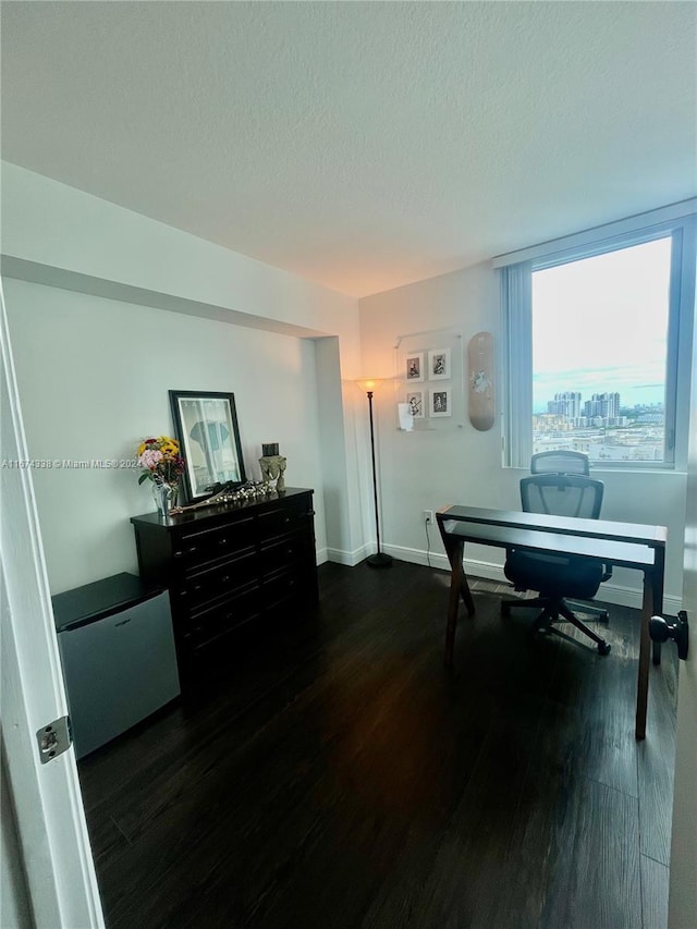 office with a textured ceiling, wood finished floors, and baseboards