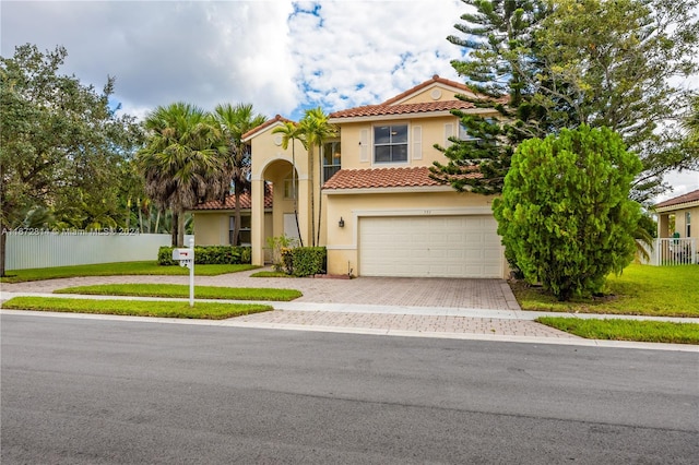 mediterranean / spanish-style house with a garage and a front lawn