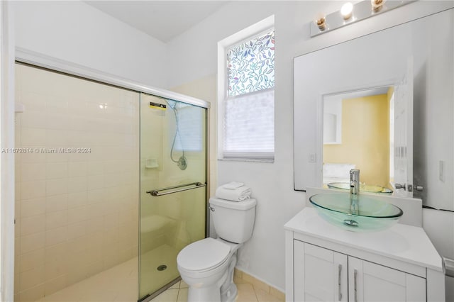 bathroom featuring tile patterned floors, a shower with shower door, vanity, and toilet