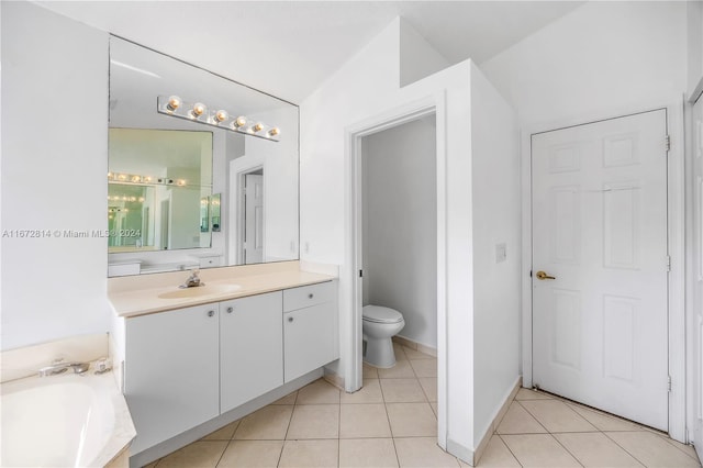 bathroom with vanity, toilet, a bath, tile patterned floors, and vaulted ceiling