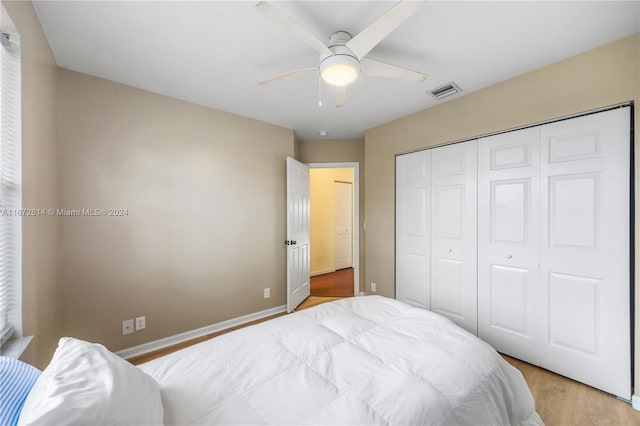 bedroom featuring a closet, light hardwood / wood-style flooring, and ceiling fan