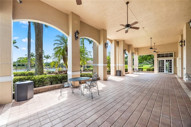 view of patio / terrace featuring ceiling fan, french doors, and a water view