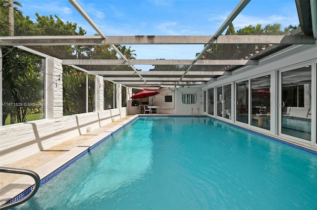 view of swimming pool featuring a patio area and glass enclosure