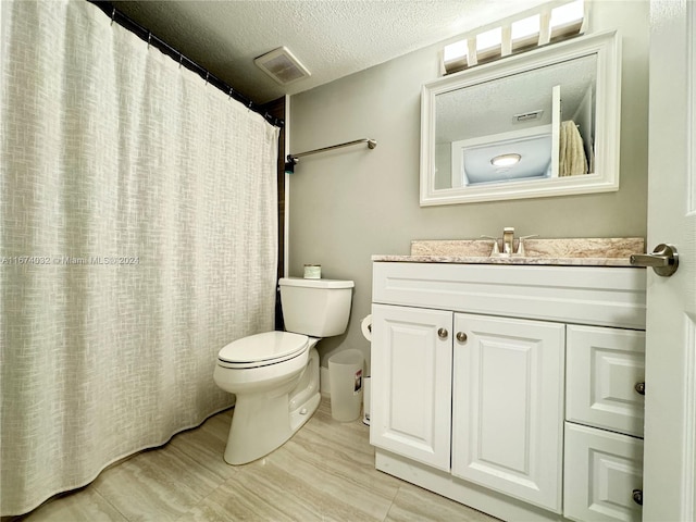 bathroom featuring vanity, curtained shower, a textured ceiling, and toilet