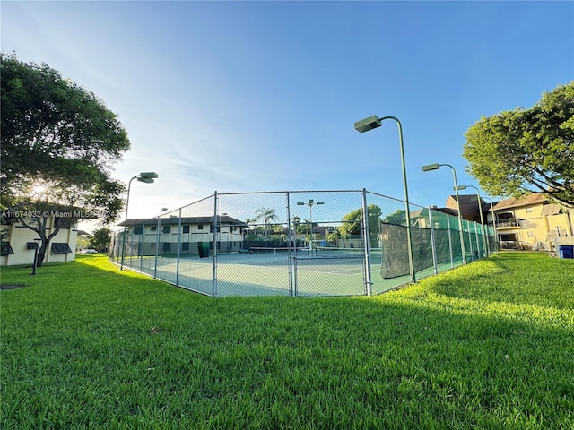 view of tennis court with a lawn